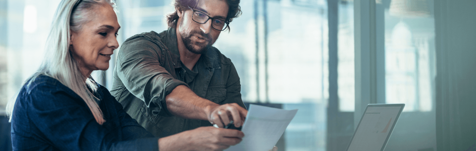Two people in an office discussing a document.